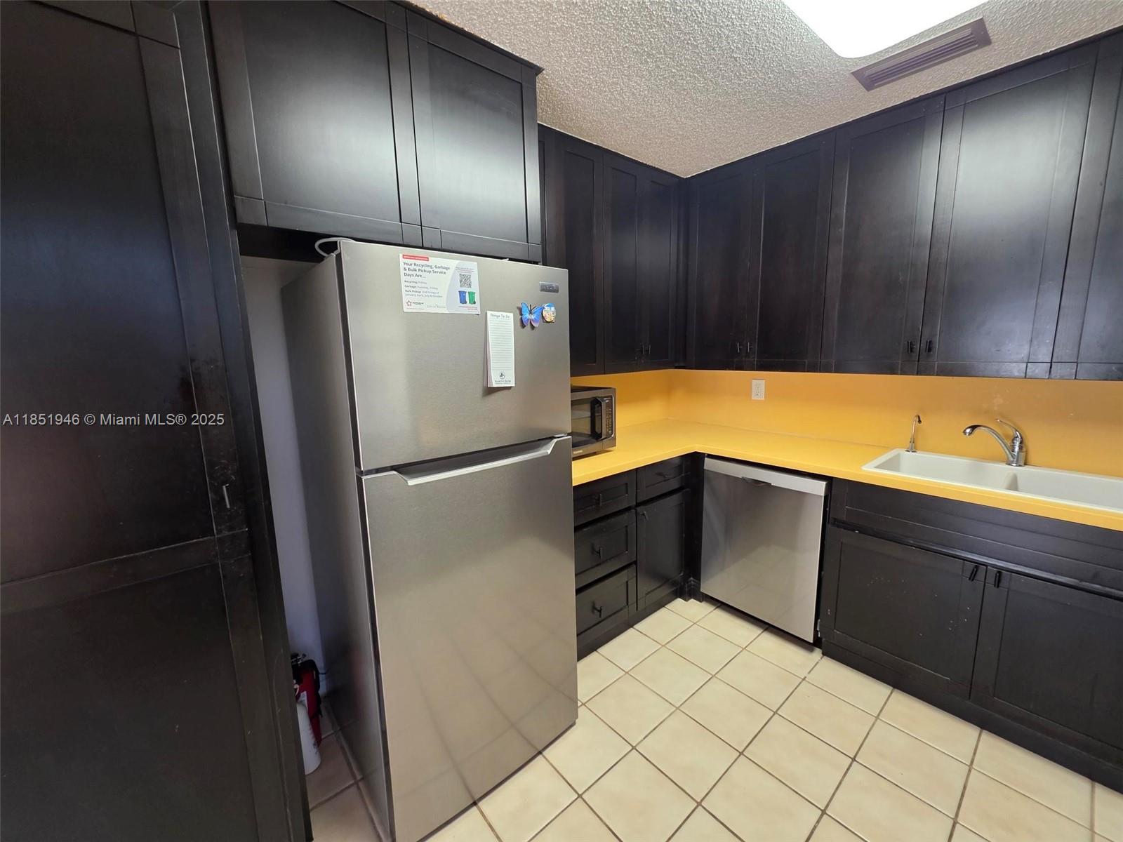 2320 Dover, Unit 2320 Weston, FL 33326 - Photo 12 of 44 a kitchen with a refrigerator and cabinets