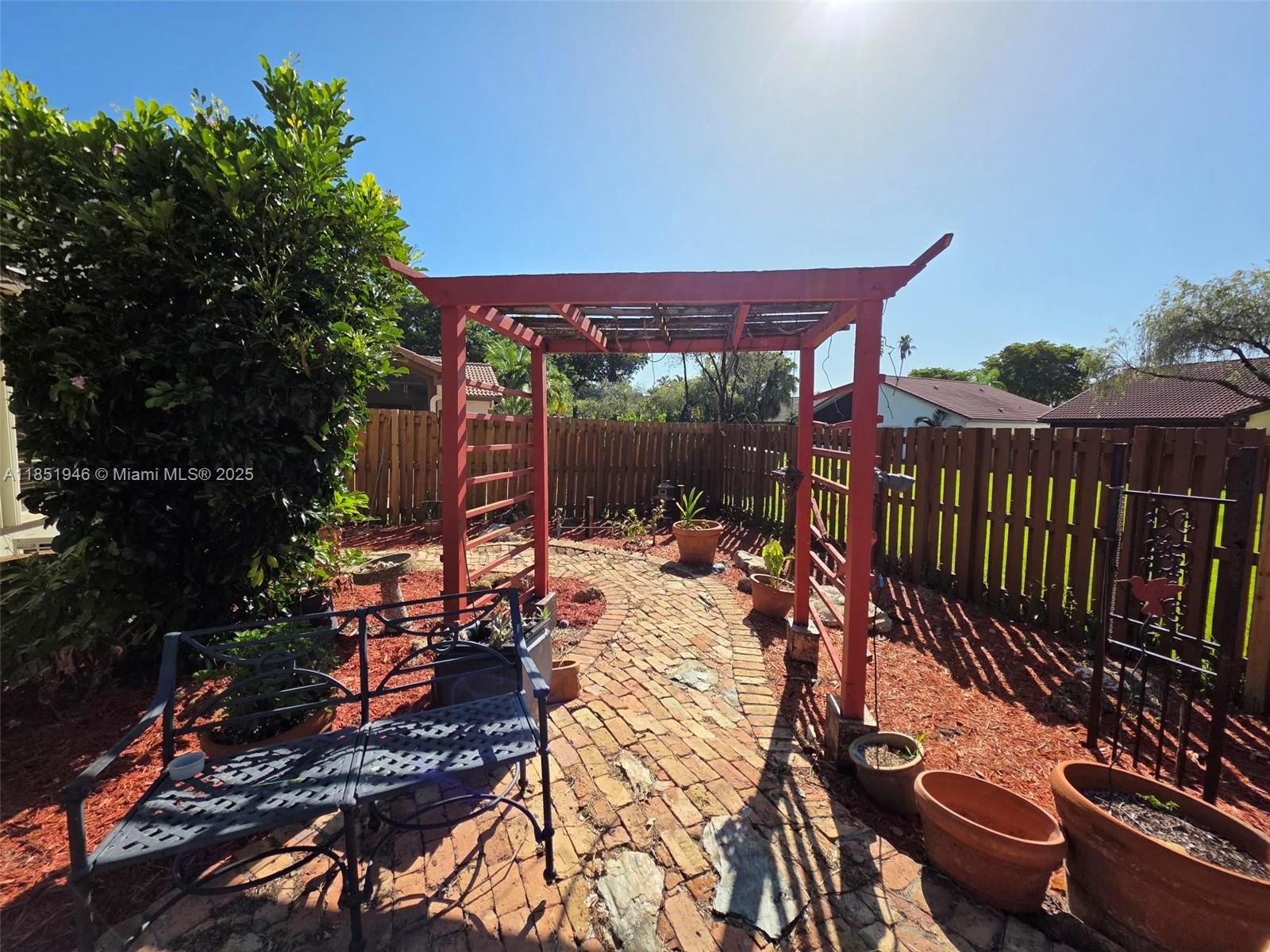 2320 Dover, Unit 2320 Weston, FL 33326 - Photo 23 of 44 a view of a patio with table and chairs potted plants with wooden floor and fence