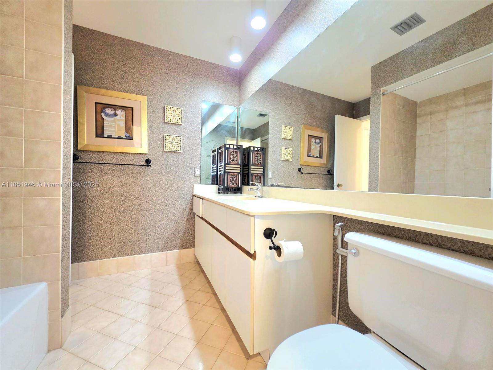2320 Dover, Unit 2320 Weston, FL 33326 - Photo 37 of 44 a bathroom with a sink a mirror and a toilet