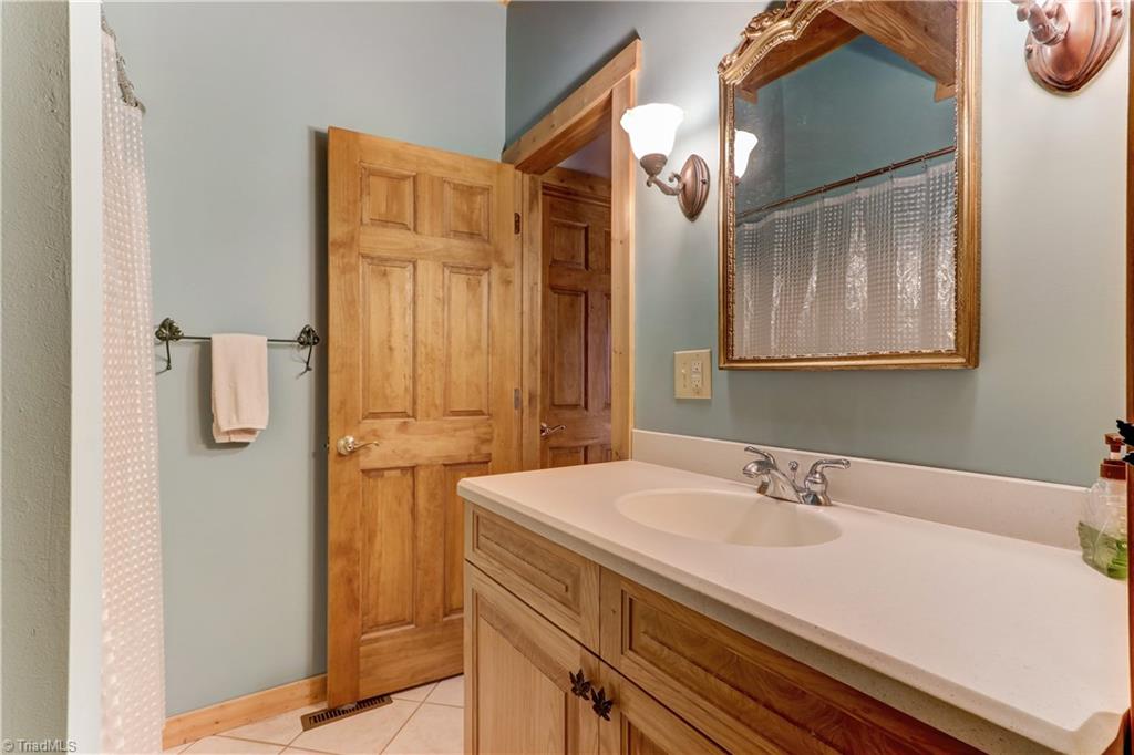 8605 Tuttle Ridge Road Germanton, NC 27019 - Photo 15 of 30 A full bath on the main level with ceramic tile floor. This Bathroom has access from the side entry hall way and the vestibule of the second bedroom on the main level.