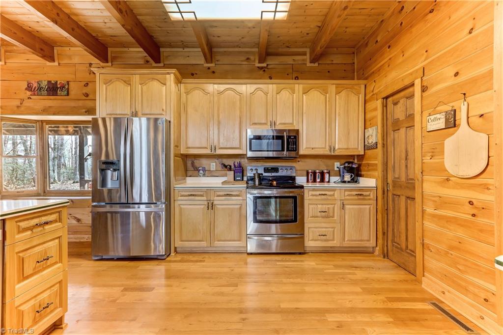 8605 Tuttle Ridge Road Germanton, NC 27019 - Photo 5 of 30 Stainless steel appliances contribute to this kitchen. To the right is a pantry with pocket doors for added convenience.