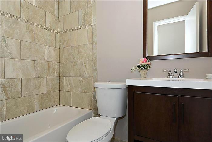 10618 Glenwild Road Silver Spring, MD 20901 - Photo 3 of 19 a bathroom with a sink mirror vanity toilet and bathtub