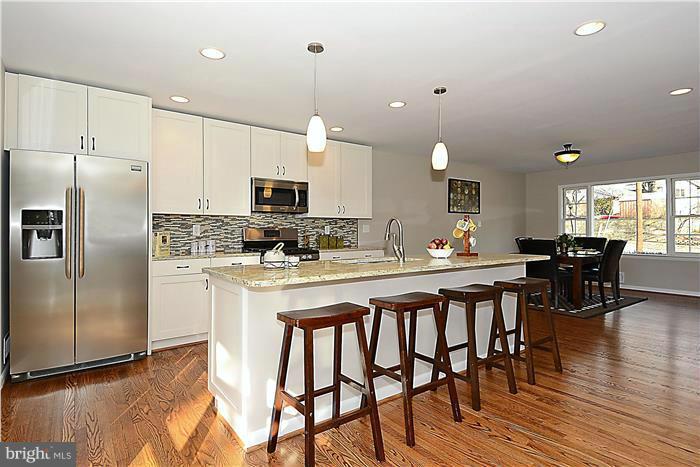 10618 Glenwild Road Silver Spring, MD 20901 - Photo 8 of 19 a kitchen with stainless steel appliances a dining table chairs stove refrigerator and cabinets