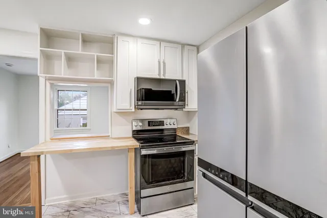a kitchen with stainless steel appliances a stove and a microwave