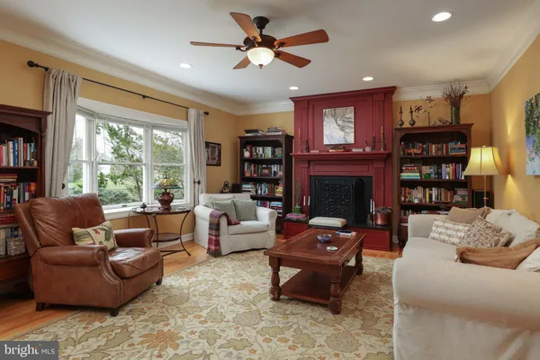 a living room with fireplace furniture and a large window