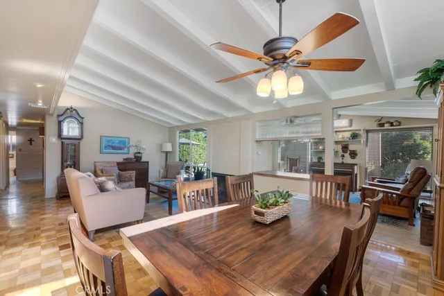 a view of a dining room with furniture a chandelier and a large window
