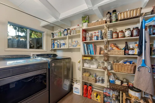 a utility room with stainless steel appliances cabinets and a window