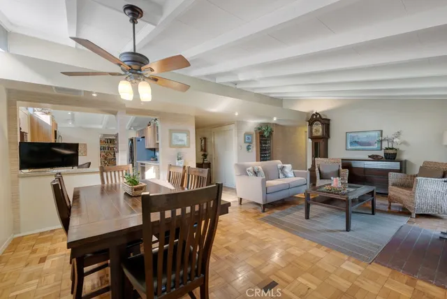 a living room with furniture a flat screen tv and kitchen view