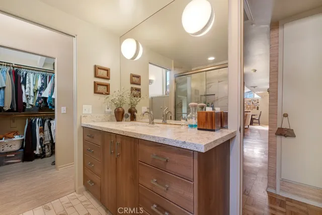 a bathroom with a granite countertop shower sink and mirror