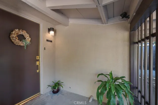 a vase with flowers sitting on a floor in front of a door