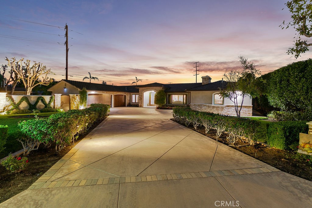 a front view of a house with a garden and plants