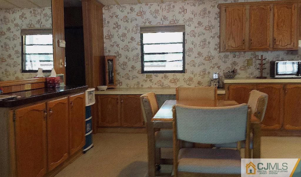 15 Longfellow Road, Unit 15 North Brunswick, NJ 08902 - Photo 7 of 12 a kitchen with a table chairs sink and cabinets