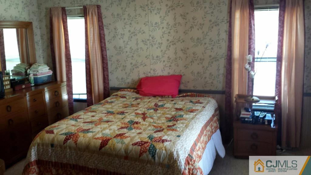 15 Longfellow Road, Unit 15 North Brunswick, NJ 08902 - Photo 9 of 12 a bedroom with a bed and a potted plant