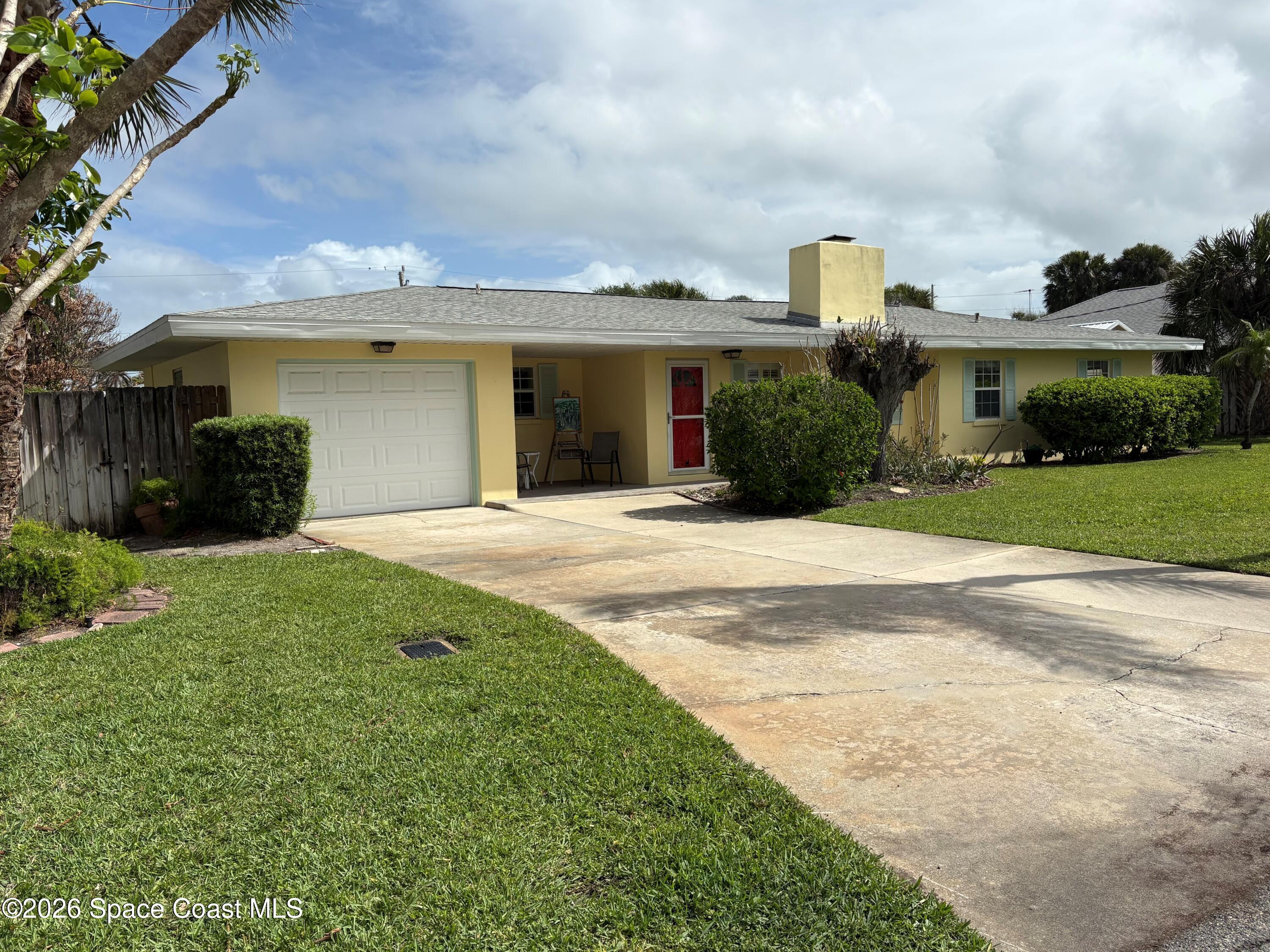 212 Surf Road Melbourne Beach, FL 32951 - Photo 1 of 14 a front view of a house with a yard and garage