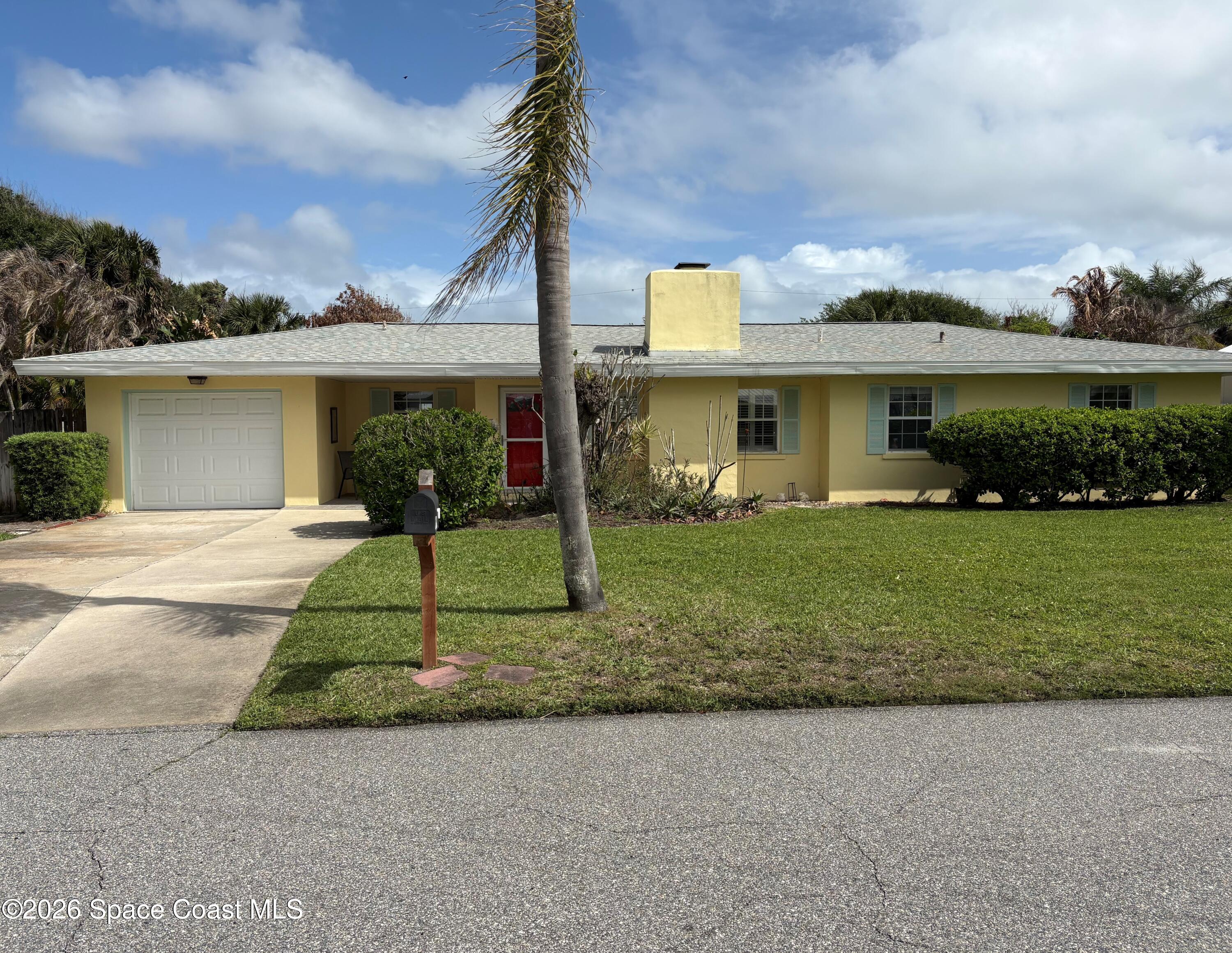 212 Surf Road Melbourne Beach, FL 32951 - Photo 2 of 14 a front view of a house with a yard and potted plants
