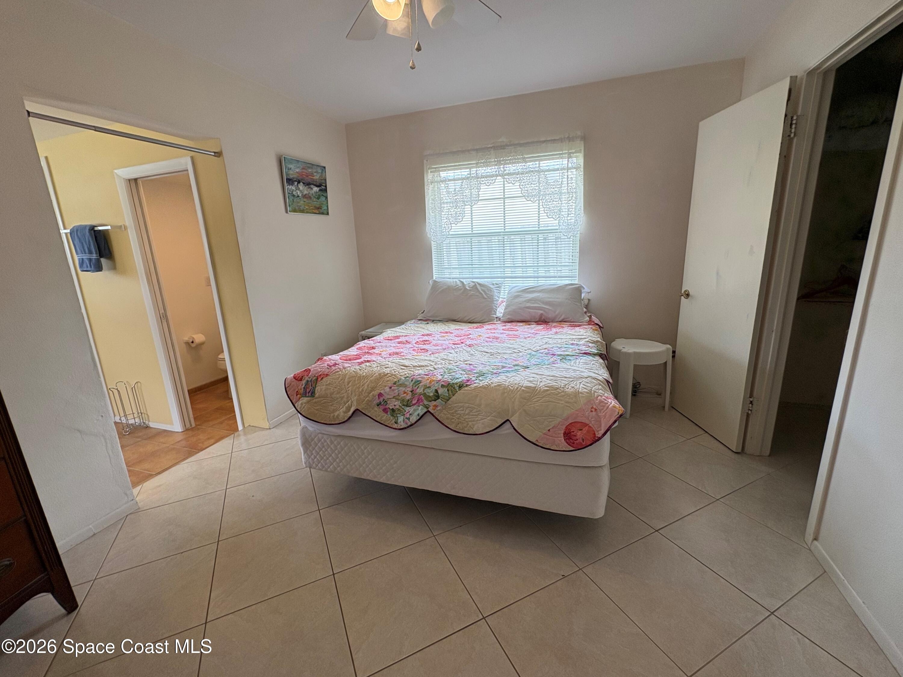 212 Surf Road Melbourne Beach, FL 32951 - Photo 3 of 14 a bedroom with a bed and a window
