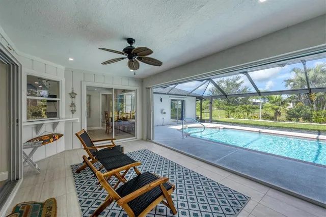 a living room with patio furniture and a floor to ceiling window