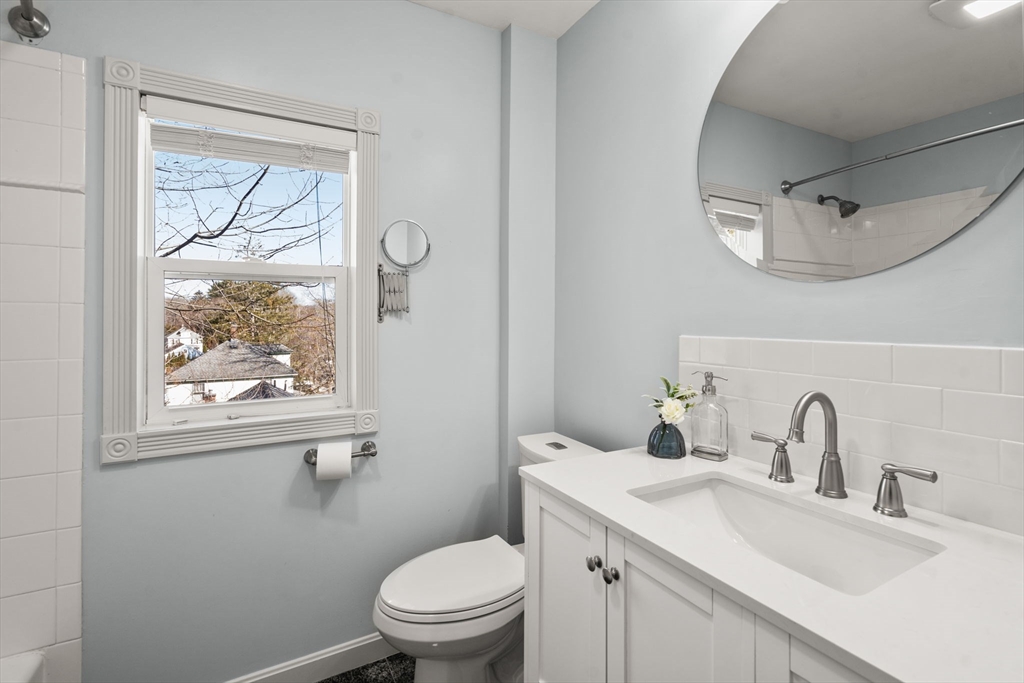 38 Fairfield Street Maynard, MA 01754 - Photo 18 of 42 a bathroom with a toilet a sink a mirror and a window