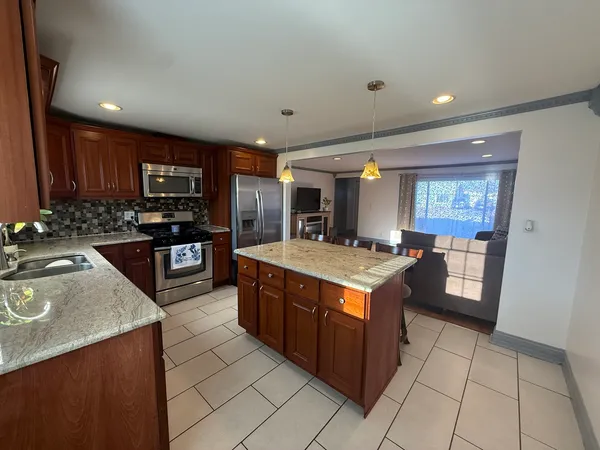 a kitchen with stainless steel appliances granite countertop wooden cabinets a sink and a stove