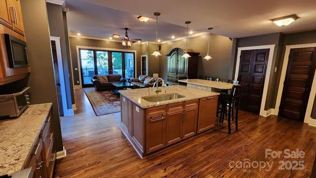 a large kitchen with stainless steel appliances granite countertop a lot of counter space and wooden floors