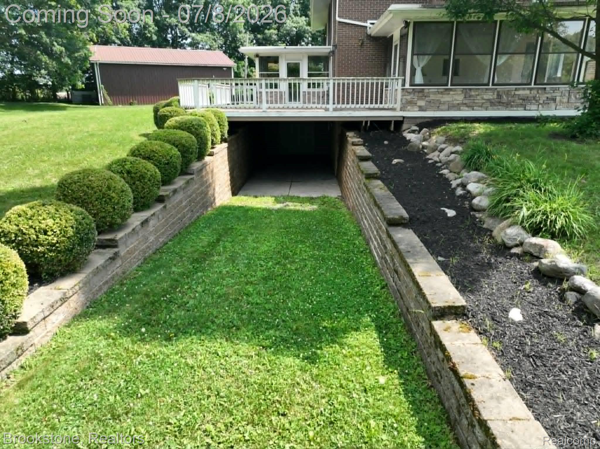 4140 South Henderson Road Davison, MI 48423 - Photo 88 of 98 Terraced landscaping featuring a stone block retaining wall with spherical evergreen plantings