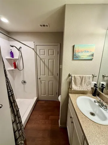 a bathroom with a sink and mirror with bathtub
