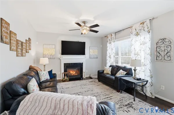 a living room with furniture a fireplace and a flat screen tv