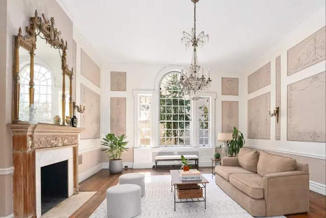 a living room with furniture a fireplace and a chandelier