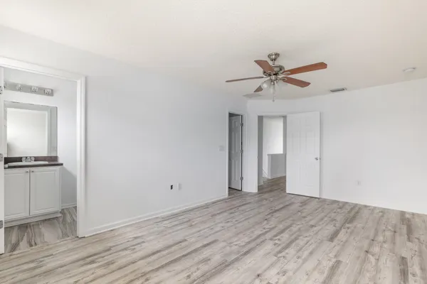 a view of a room with wooden floor and a ceiling fan