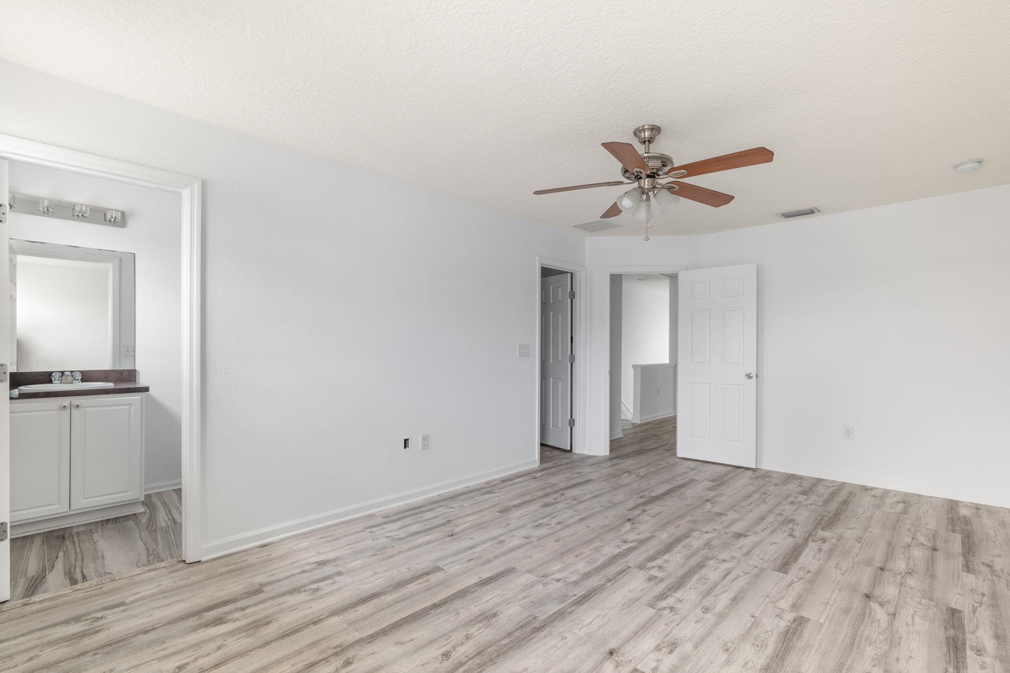 128 Islander Circle St. Augustine, FL 32080 - Photo 12 of 24 a view of a room with wooden floor and a ceiling fan