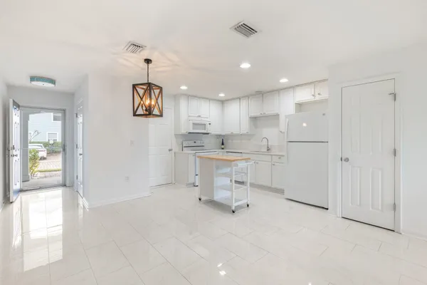 a kitchen with a refrigerator and white cabinets