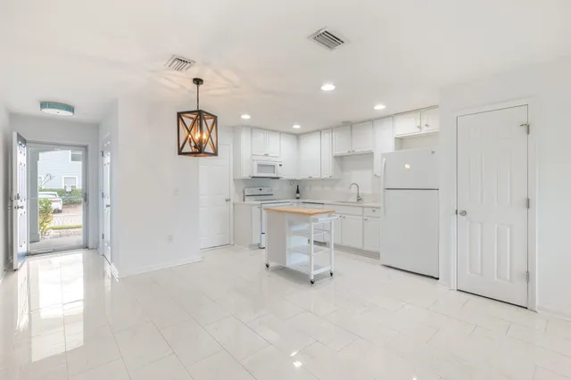 a kitchen with a refrigerator and white cabinets