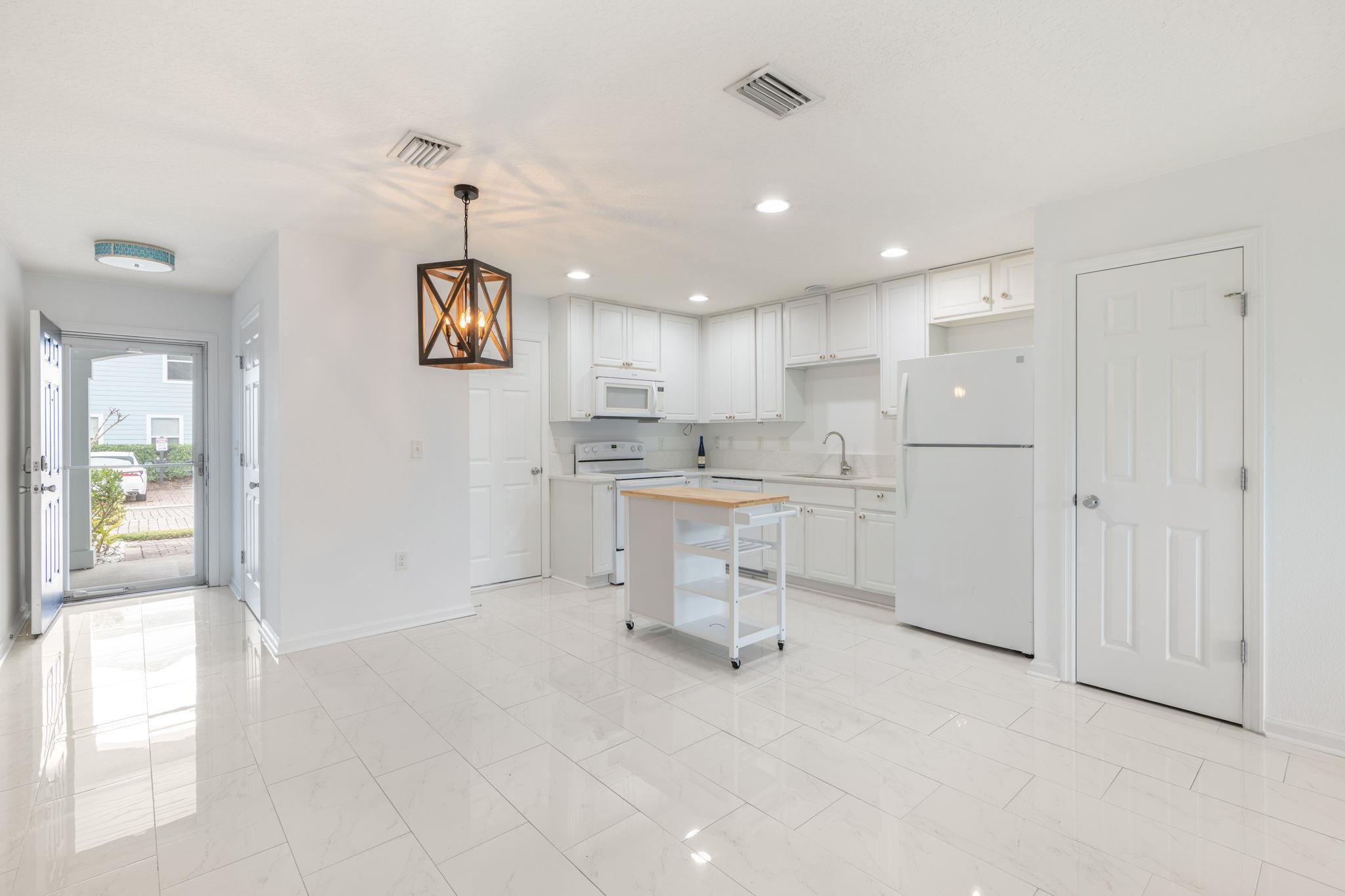 128 Islander Circle St. Augustine, FL 32080 - Photo 4 of 24 a kitchen with a refrigerator and white cabinets