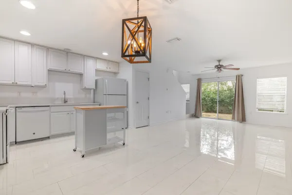 a kitchen with white cabinets and window