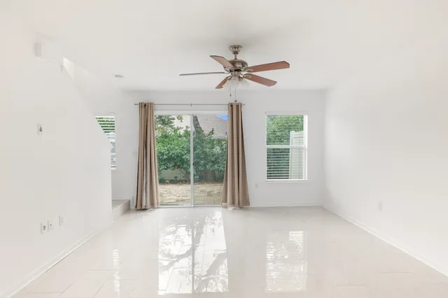 a view of room with balcony and ceiling fan