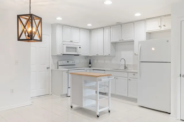 a kitchen with white cabinets and white appliances