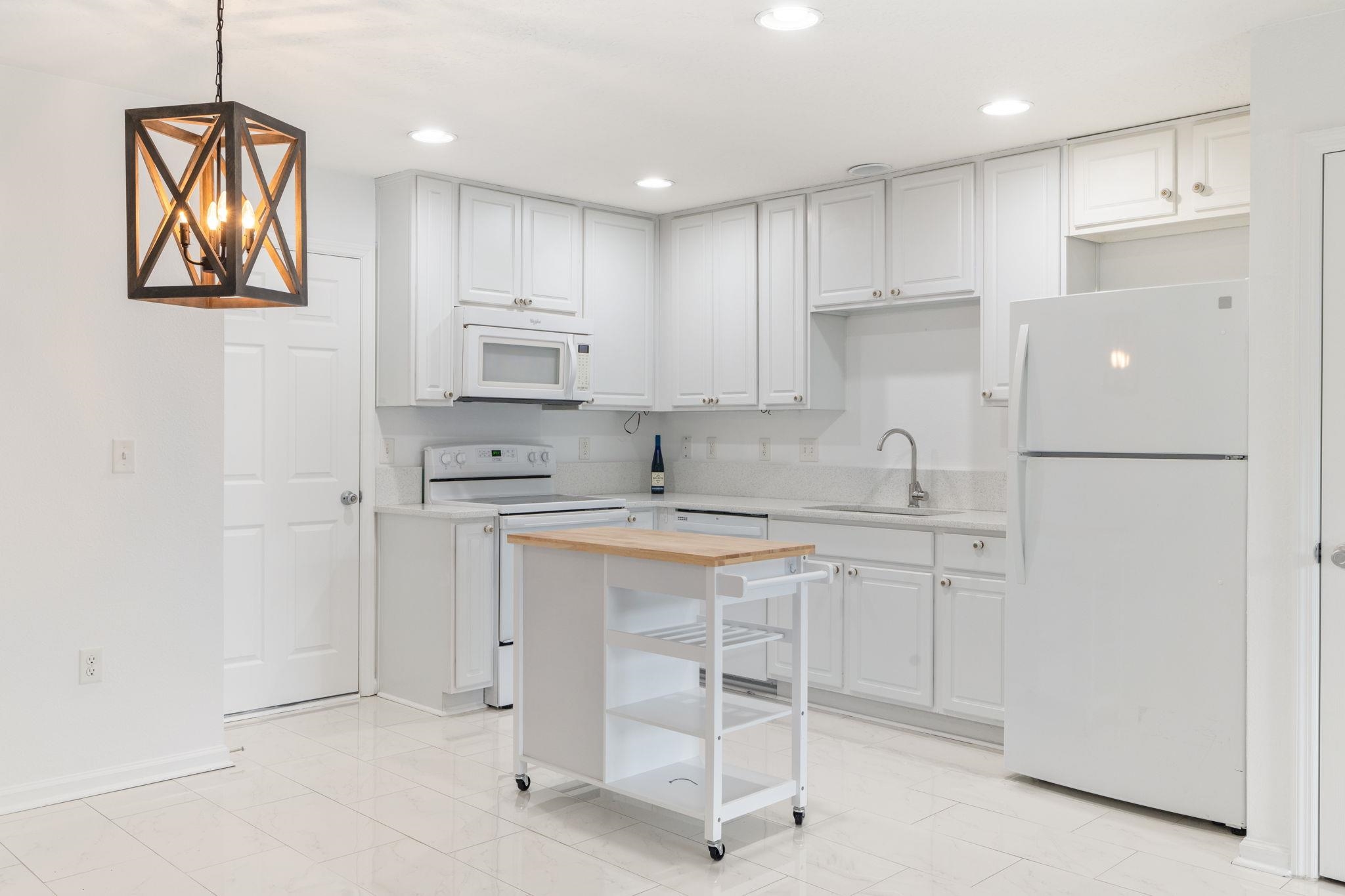 128 Islander Circle St. Augustine, FL 32080 - Photo 7 of 24 a kitchen with white cabinets and white appliances