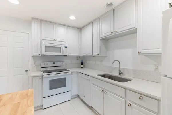 a kitchen with white cabinets stainless steel appliances and sink