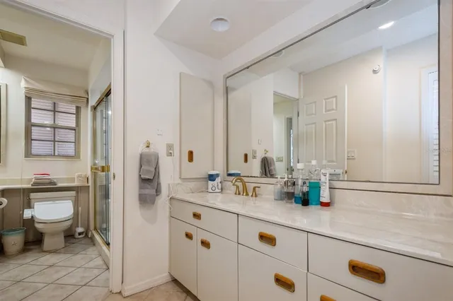 a bathroom with a granite countertop sink mirror and toilet