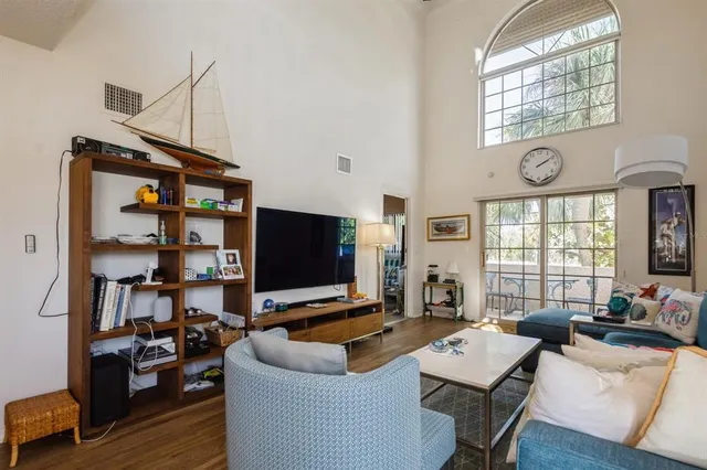 a living room with furniture a flat screen tv and a window