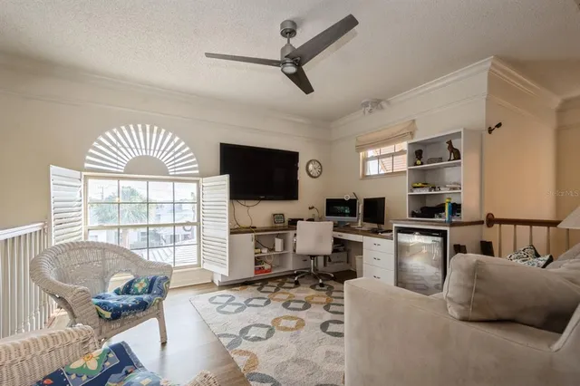 a living room with furniture a flat screen tv and a large window