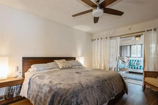 a bedroom with a large bed and a chandelier fan