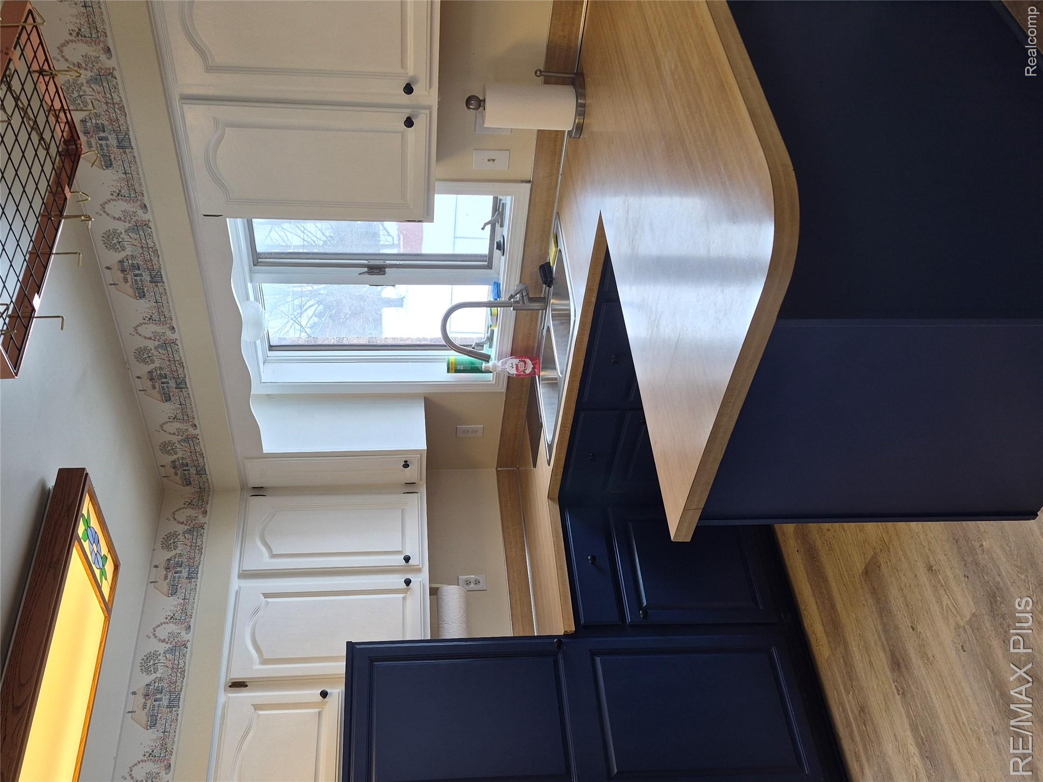 1115 Turrill Road Lapeer, MI 48446 - Photo 11 of 50 Kitchen featuring two tone color scheme, a peninsula, light countertops, and light wood-style flooring