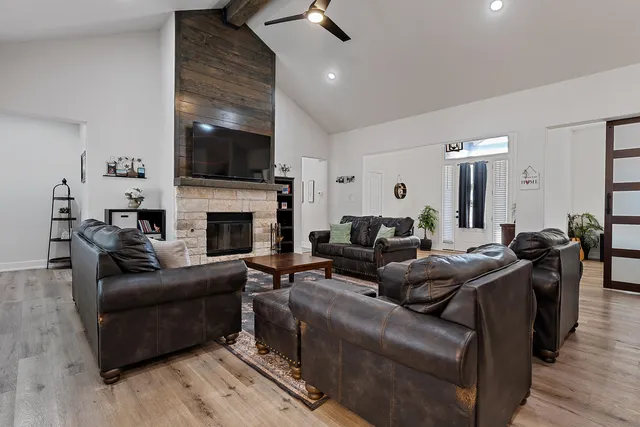 a living room with furniture kitchen view and a flat screen tv