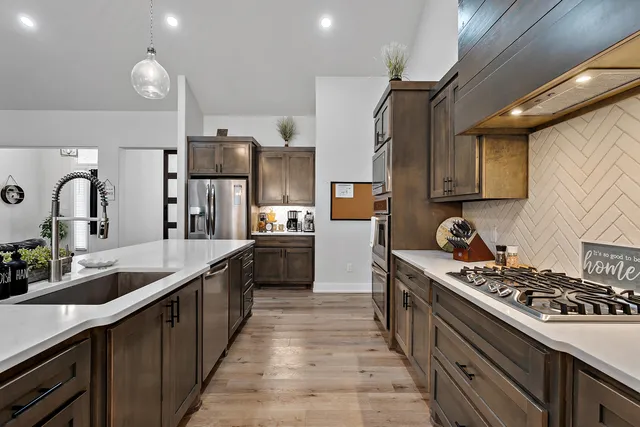 a kitchen with stainless steel appliances granite countertop a table chairs sink refrigerator and microwave