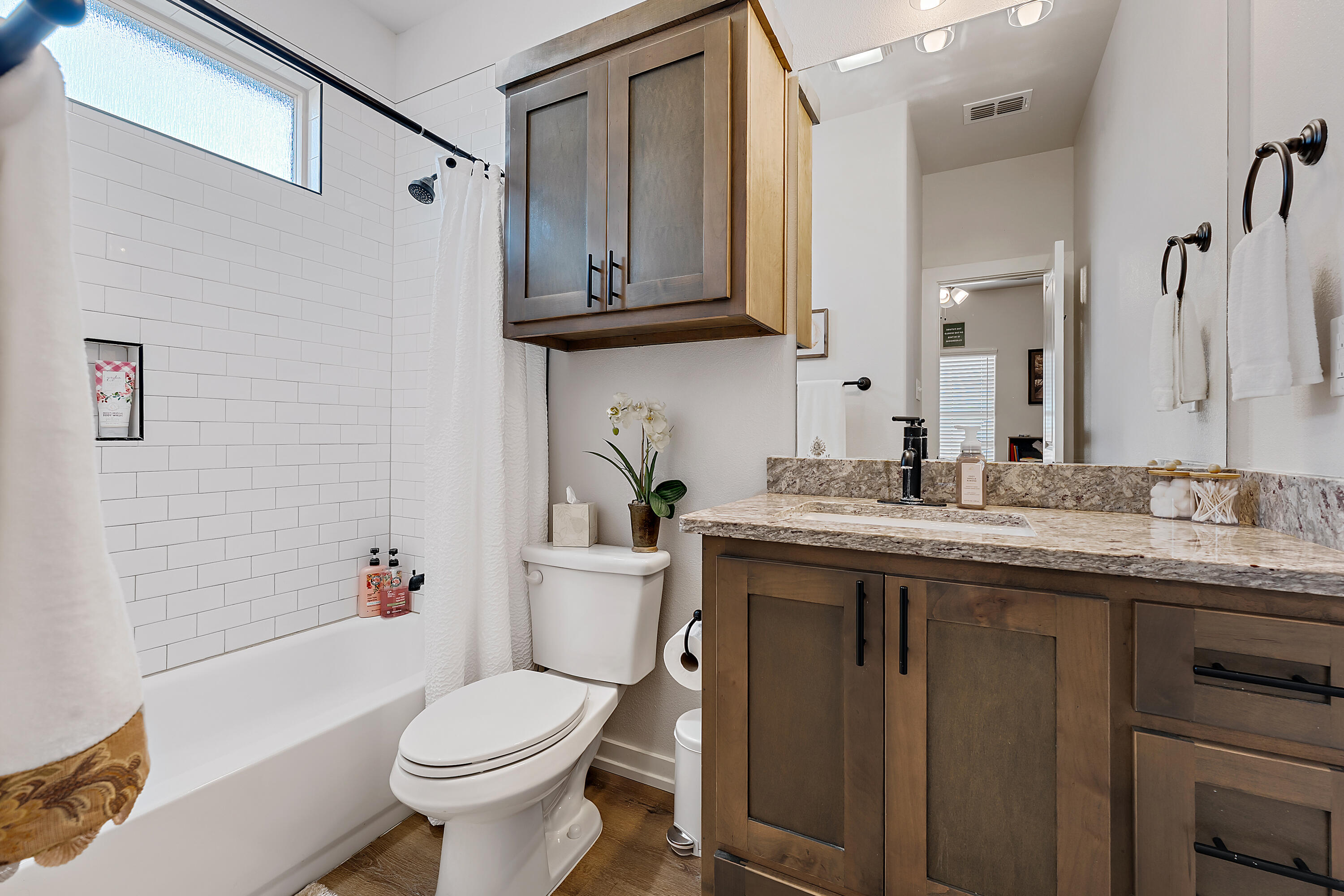 9218 County Road 6870 Lubbock, TX 79407 - Photo 29 of 45 a bathroom with a granite countertop toilet sink and mirror with bathtub