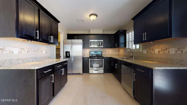 a kitchen with stainless steel appliances granite countertop a refrigerator and a sink