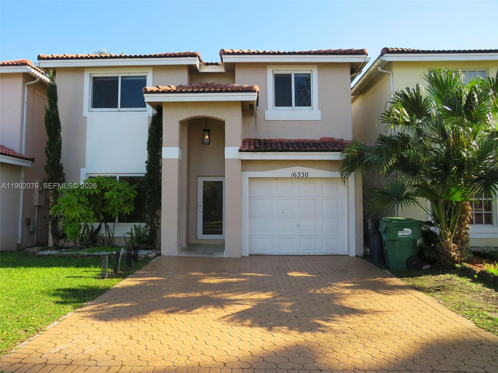 a view of a house with a backyard and a garage