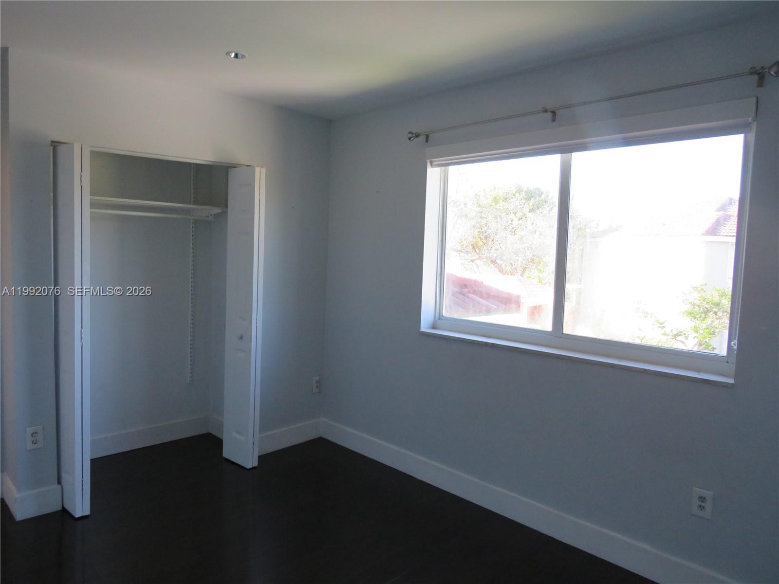 16330 Southwest 102nd Street Miami, FL 33196 - Photo 22 of 30 an empty room with wooden floor and windows