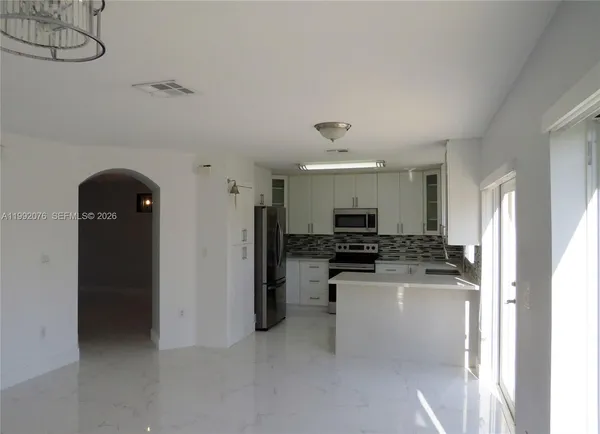 a kitchen with refrigerator and cabinets